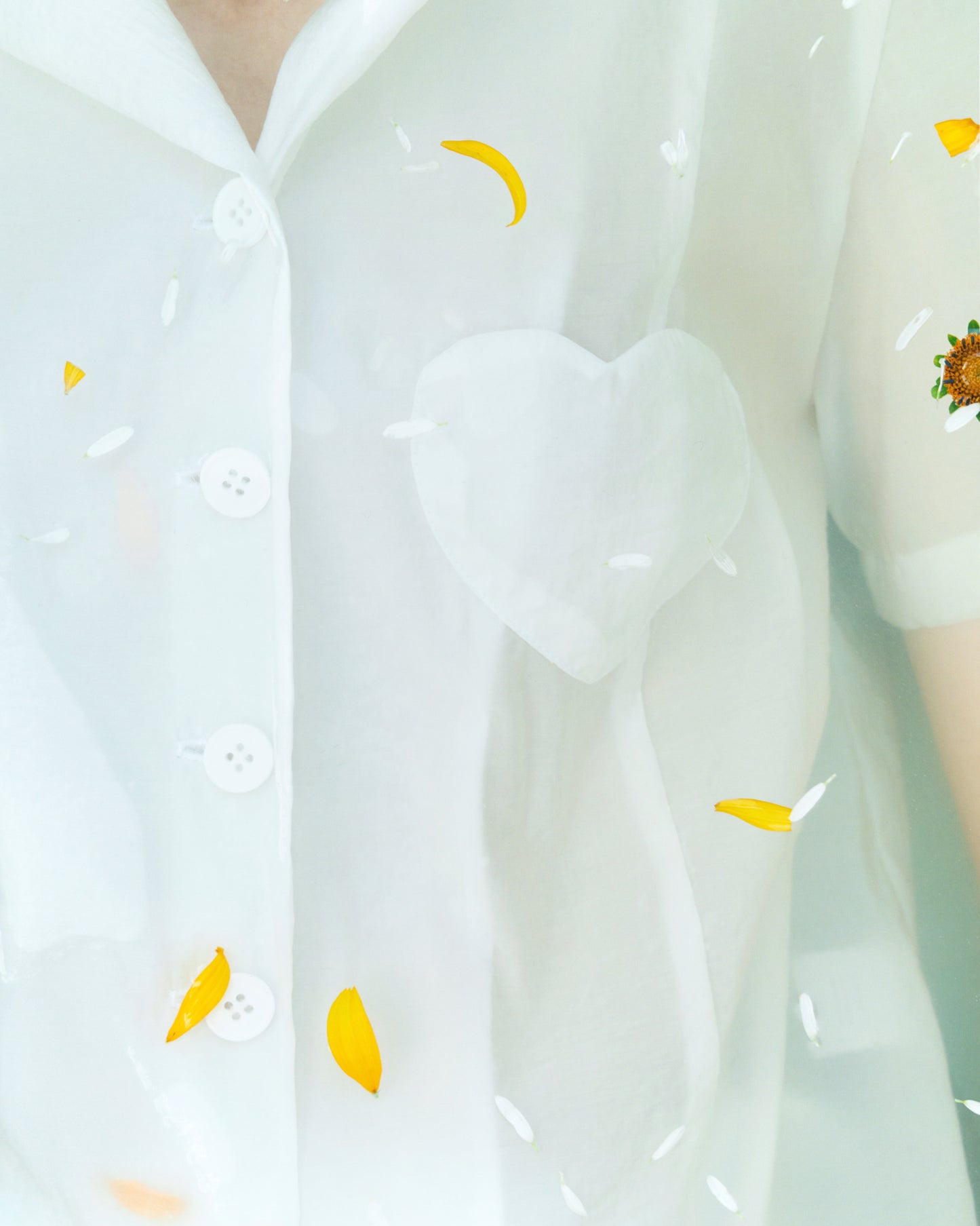 stunning white shirt, featuring a chic lapel collar, short sleeves, and a straight hem. The shirt is designed with a unique twist, featuring a chest heart patch pocket for added style. With a flattering side slit and a front button fastening, this shirt is perfect for any occasion. Match this with our viscose white balloon skirt and wear it like a suit for a stylish and coordinated look, FORMA fashion brand