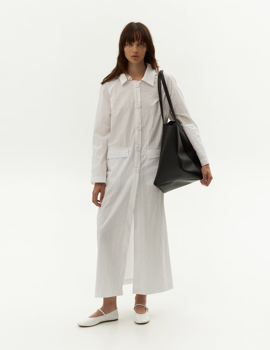 Stay stylish and dry with our white waterproof raincoat. Crafted from durable waterproof fabric, this coat is your perfect companion on rainy days. It features two convenient pockets to keep your essentials safe and a removable hood for added versatility. The wrinkled fabric of this waterproof white raincoat adds a unique texture, giving it a distinctive and stylish appeal. Forma brand clothing